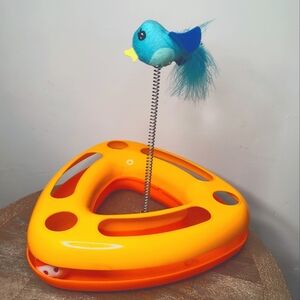 Interactive cat toy with white golf ball inside and blue birdie attached